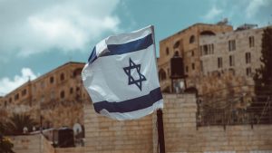 Photo of Israeli flag in from of some buildings