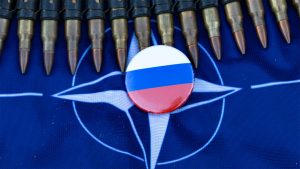 NATO flag with a Russian pin and ammunition