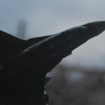 A fighter jet flying through a cloudy sky