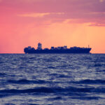 A photo of an oil tanker set against a red orange sunset