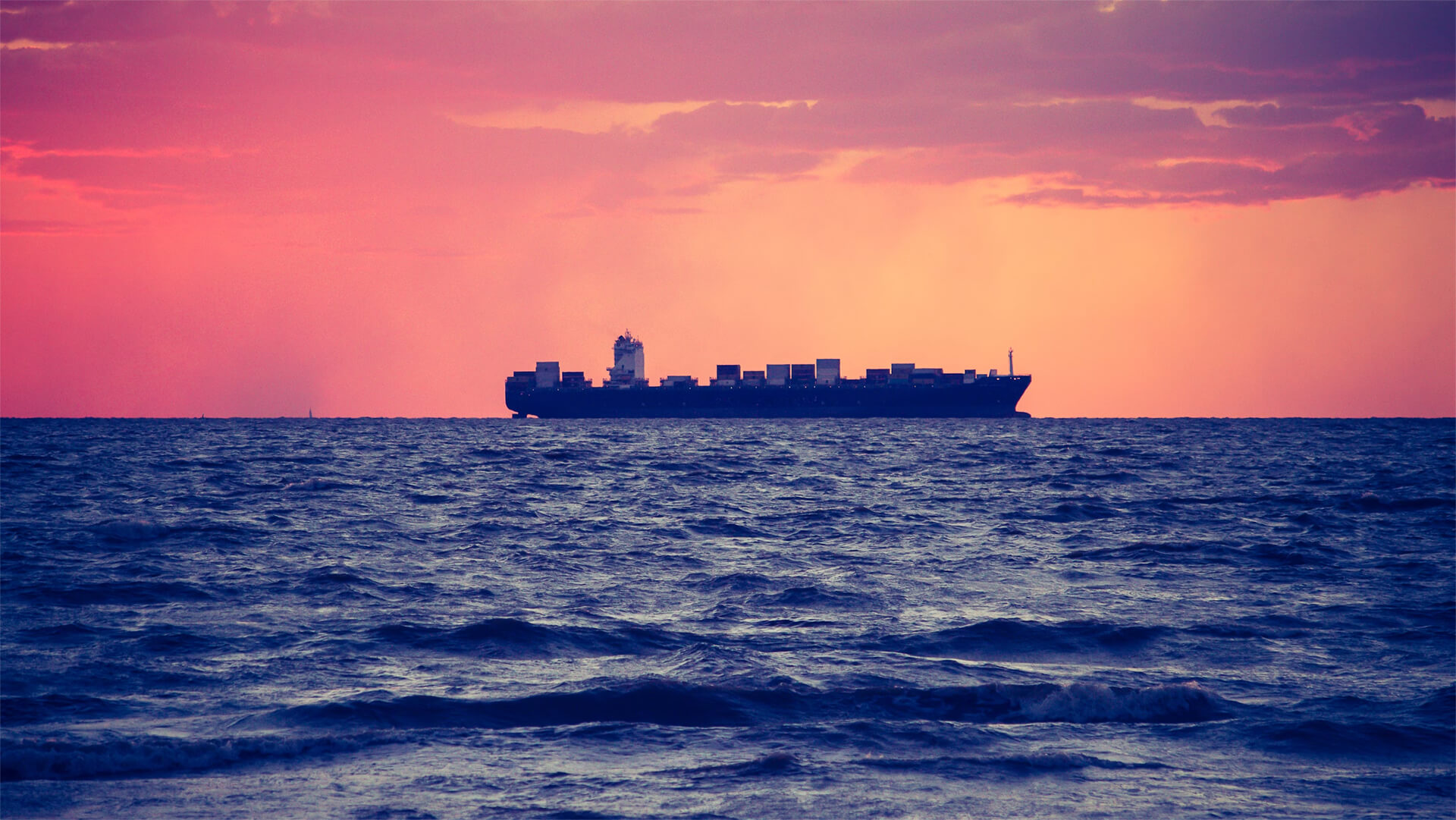 A photo of an oil tanker set against a red orange sunset