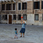 An elder woman plays basketball with a child