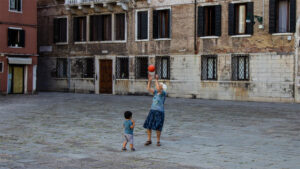 An elder woman plays basketball with a child