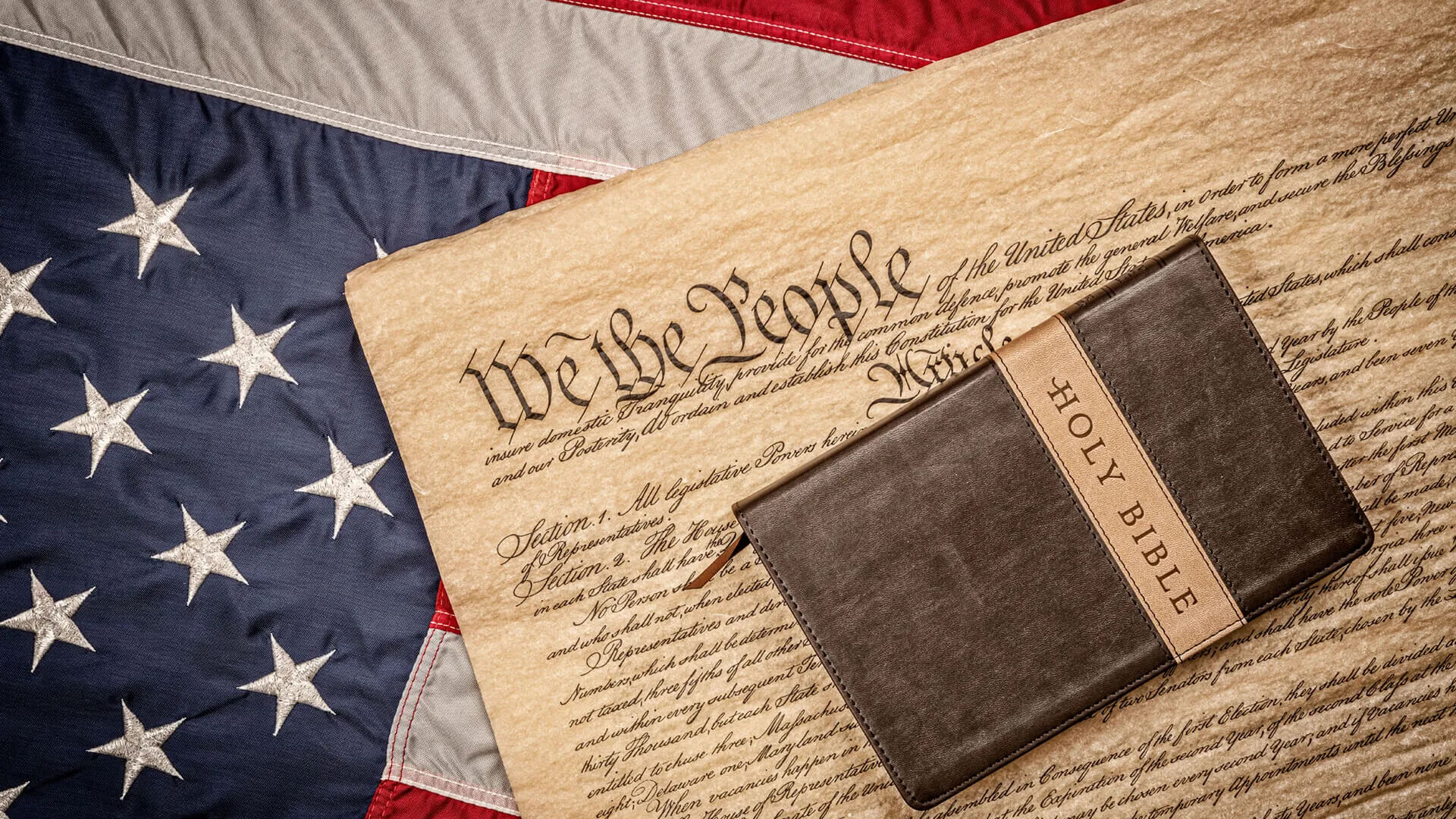 Photo of a bible on the US constitution and flag