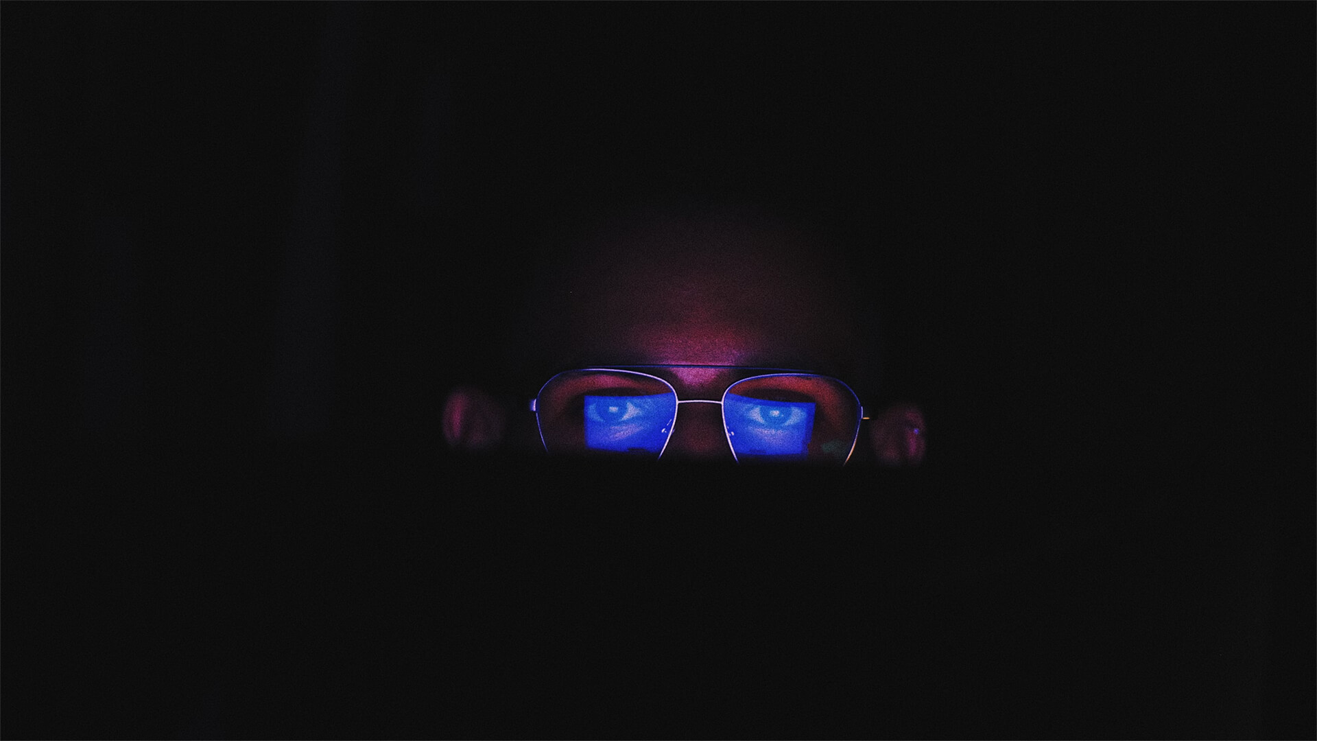 Man looking a computer screen with reflection