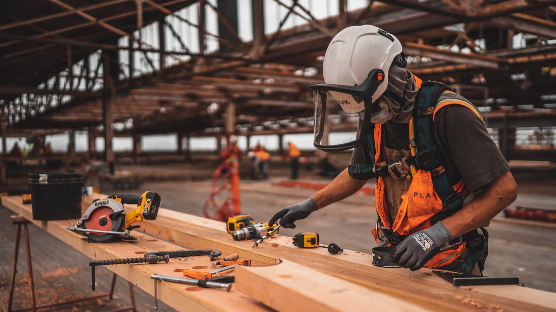 A construction workers cuts lumber in a mask