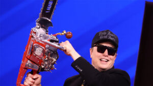 Musk swings the "Chainsaw for Bureaucracy" at CPAC 2025. From wikimedia commons: https://en.wikipedia.org/wiki/Department_of_Government_Efficiency#/media/File:Elon_Musk_(54349592271).jpg