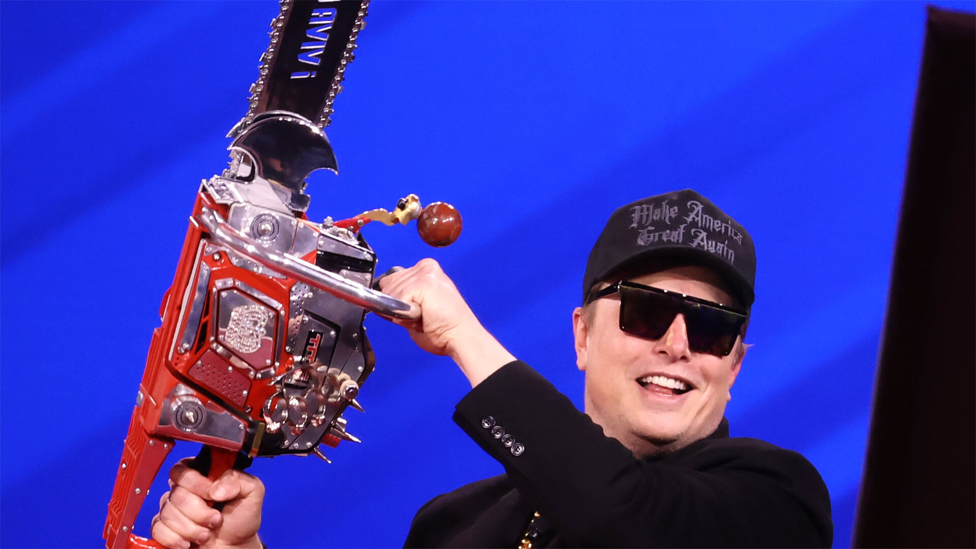 Musk swings the "Chainsaw for Bureaucracy" at CPAC 2025. From wikimedia commons: https://en.wikipedia.org/wiki/Department_of_Government_Efficiency#/media/File:Elon_Musk_(54349592271).jpg