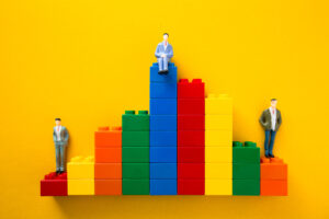 Businessmen figurines standing and sitting on top of colorful plastic blocks forming a bar chart from Envato Elements: https://elements.envato.com/businessmen-figurines-standing-and-sitting-on-top--2YBGNE8