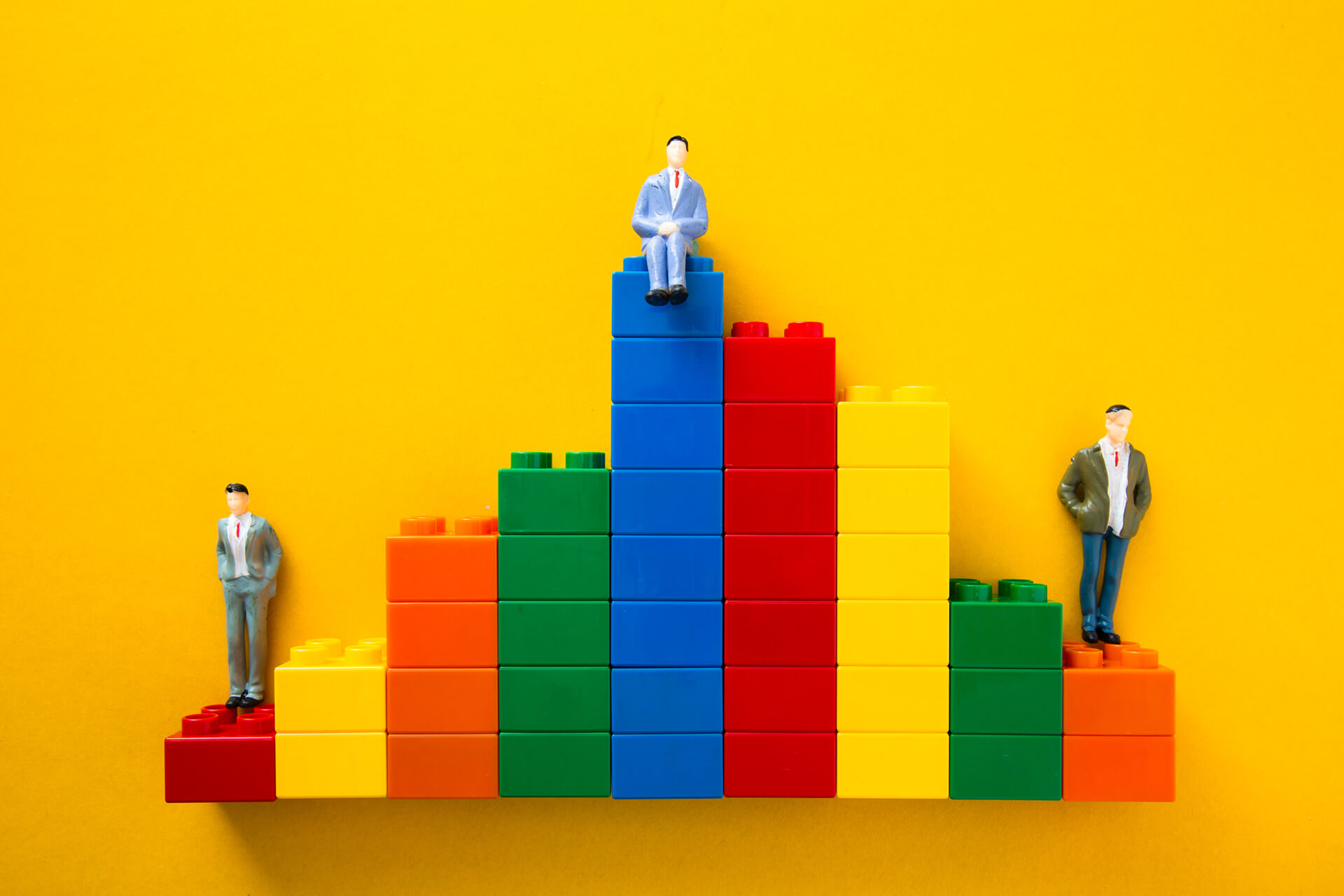 Businessmen figurines standing and sitting on top of colorful plastic blocks forming a bar chart from Envato Elements: https://elements.envato.com/businessmen-figurines-standing-and-sitting-on-top--2YBGNE8
