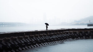 Person with umbrella standing on Xinghai Bay Bridge