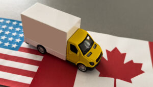 A USA-marked shipping container on a truck, illustrating American international trade from Envato Elements: https://elements.envato.com/a-usa-marked-shipping-container-on-a-truck-illustr-HMKHD83