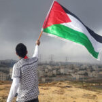 Man waving the Palestinian flag over Gaza