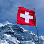 Swiss flag over snow capped mpuntains
