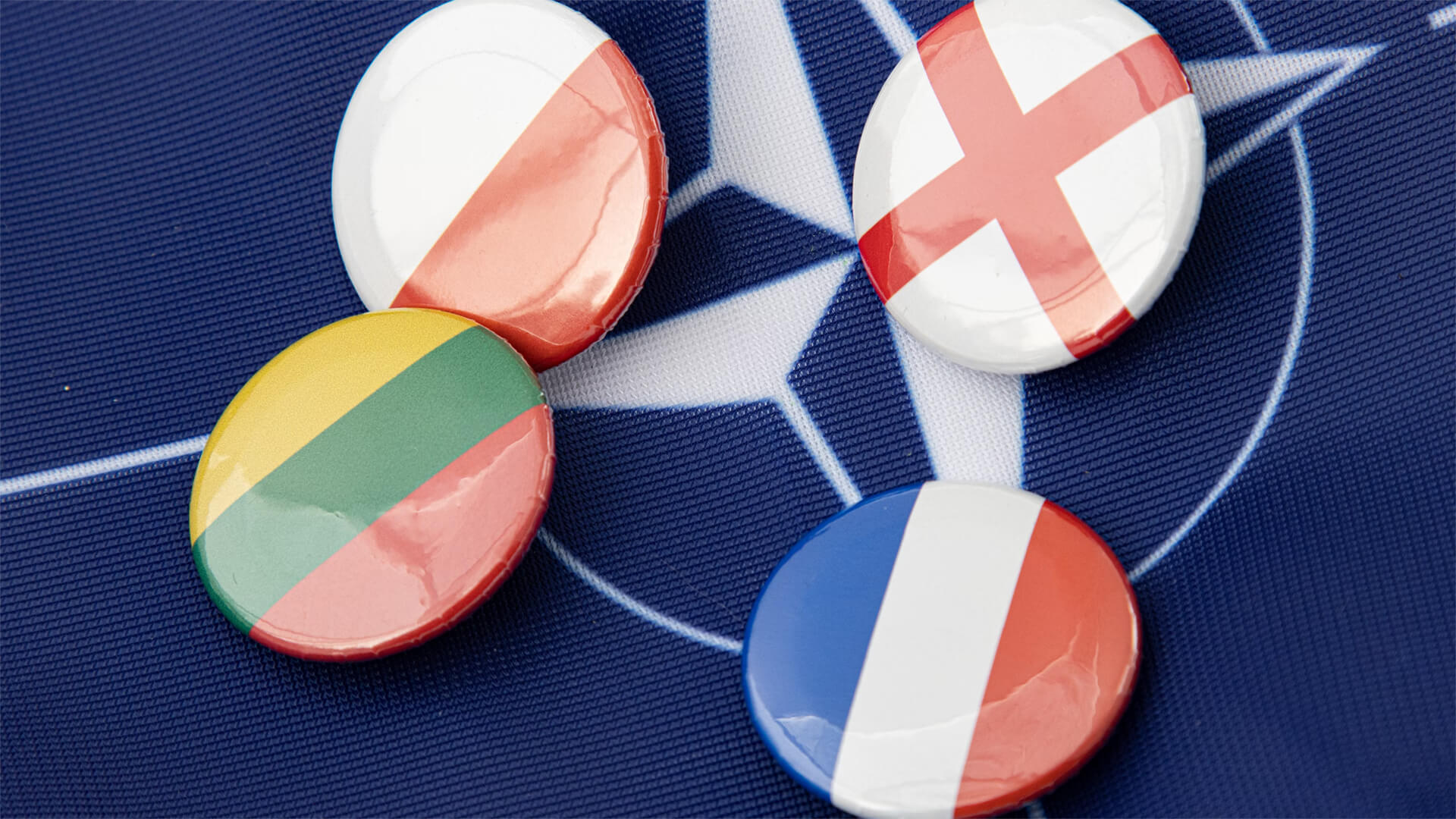 A NATO flag with buttons of other countries flags on it