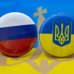 A Russia and Ukraine button on top of a Ukraine flag