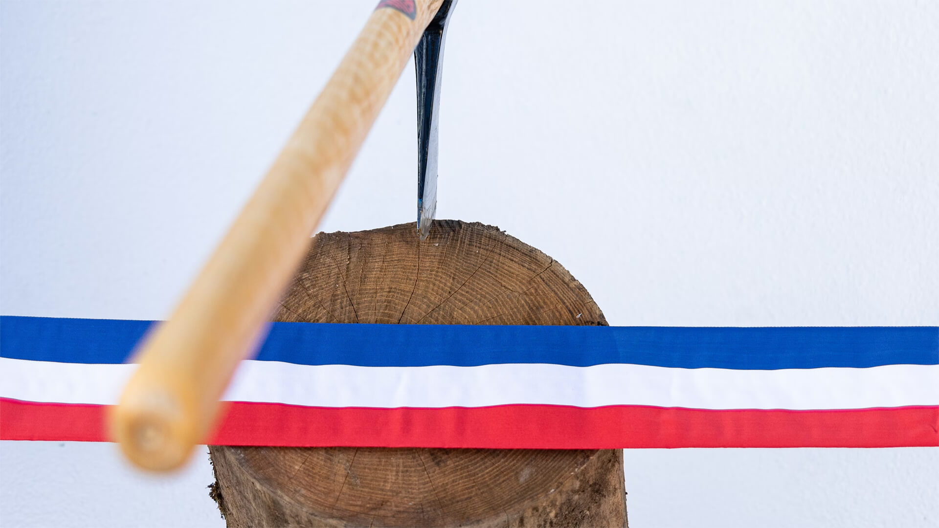 A French flag ribbon with an axe on a chopping block
