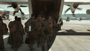 A group of Marines loading into the back of a C-130 aircraft