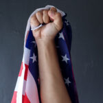 Fist raised with an American flag in it | Licensed by Envato Elements: https://app.envato.com/search/photos/939fd782-14f6-41bc-a6c2-37f108609543?itemType=photos&term=american+power&sort=relevance