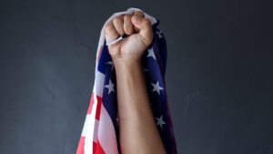 Fist raised with an American flag in it | Licensed by Envato Elements: https://app.envato.com/search/photos/939fd782-14f6-41bc-a6c2-37f108609543?itemType=photos&term=american+power&sort=relevance