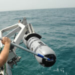An unmanned Underwater vehicle drone about to be dropped into the ocean | Courtesy of Wikimedia Commons: https://en.wikipedia.org/wiki/Unmanned_underwater_vehicle#/media/File:Unmanned_Underwater_Vehicle_operations_130605-N-AZ907-046.jpg