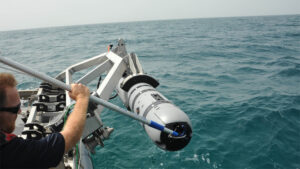 An unmanned Underwater vehicle drone about to be dropped into the ocean | Courtesy of Wikimedia Commons: https://en.wikipedia.org/wiki/Unmanned_underwater_vehicle#/media/File:Unmanned_Underwater_Vehicle_operations_130605-N-AZ907-046.jpg
