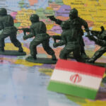 Toy soldiers advance across a map with an Iranian flag in the foreground