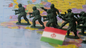 Toy soldiers advance across a map with an Iranian flag in the foreground
