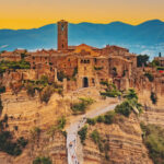 Photo of the city of Civita di Bagnoregio, Italy with mountains in the background