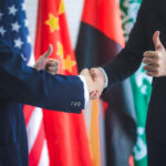 Two diplomats shaking hands in front of flags. Licensed by Envato Elements