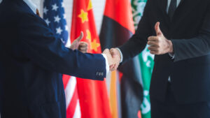 Two diplomats shaking hands in front of flags. Licensed by Envato Elements