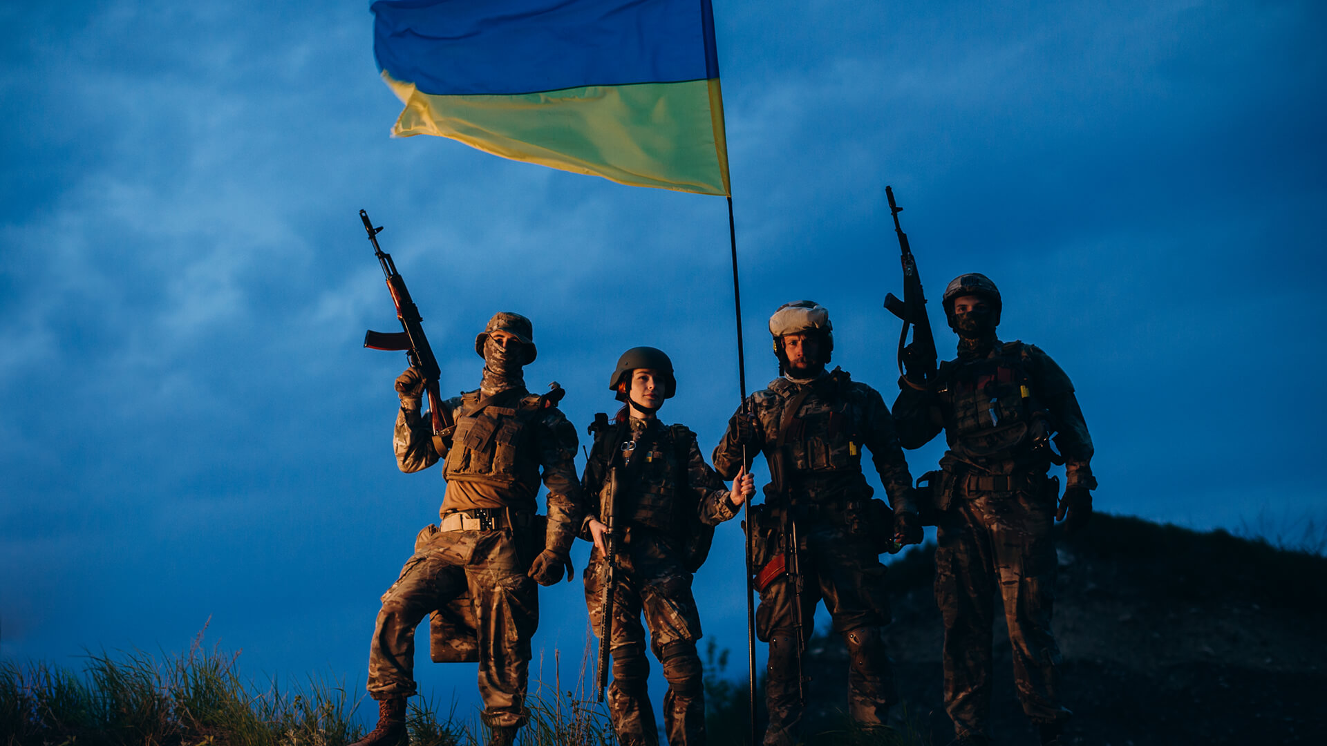 Ukrainian soldiers holding their flag against a dark sky Photo licensed by envato elements: https://app.envato.com/search/photos/1ac20b11-1fac-4c14-9452-b1e5ca99fccc?itemType=photos&term=ukraine+war
