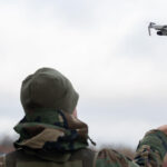 Camo clad man flying a drone outdoors | License by Envato Elements