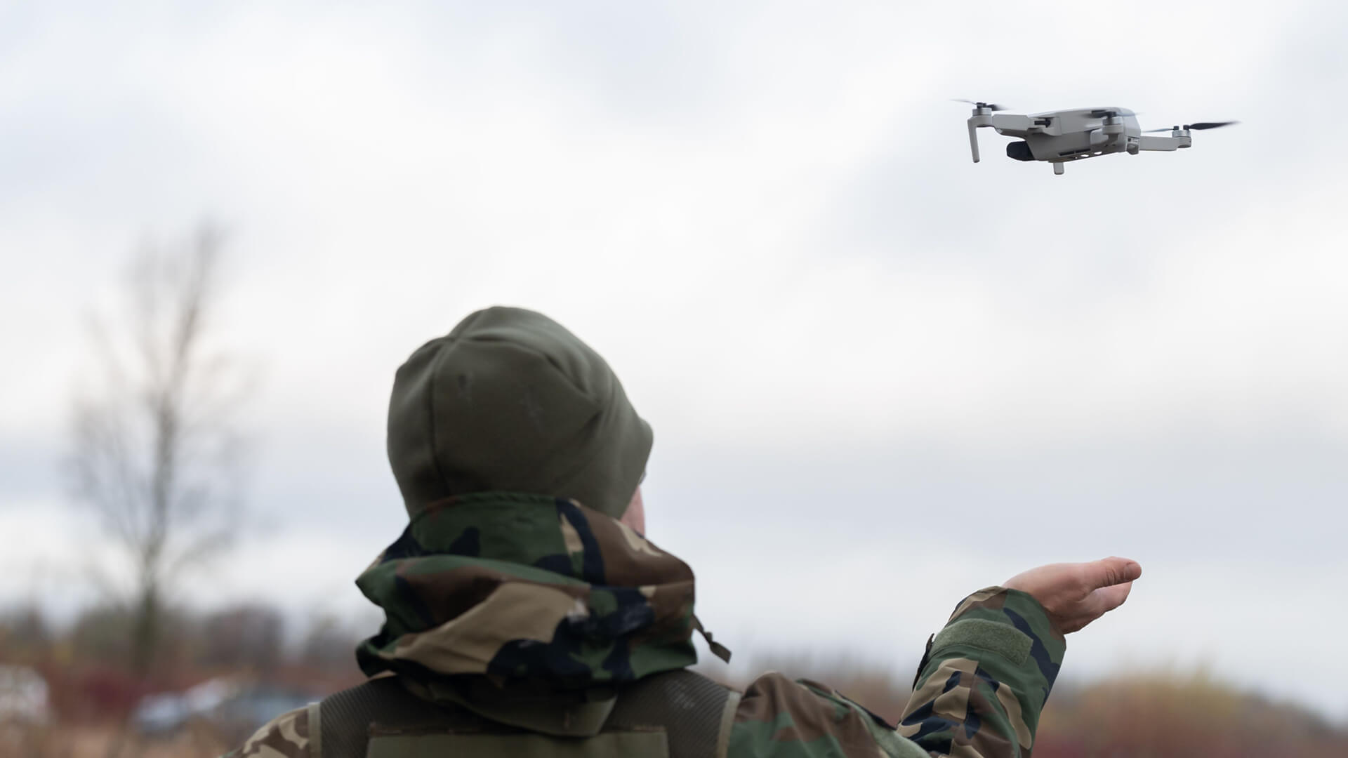 Camo clad man flying a drone outdoors | License by Envato Elements