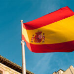 Flag of Spain waving in the wind in front of a building