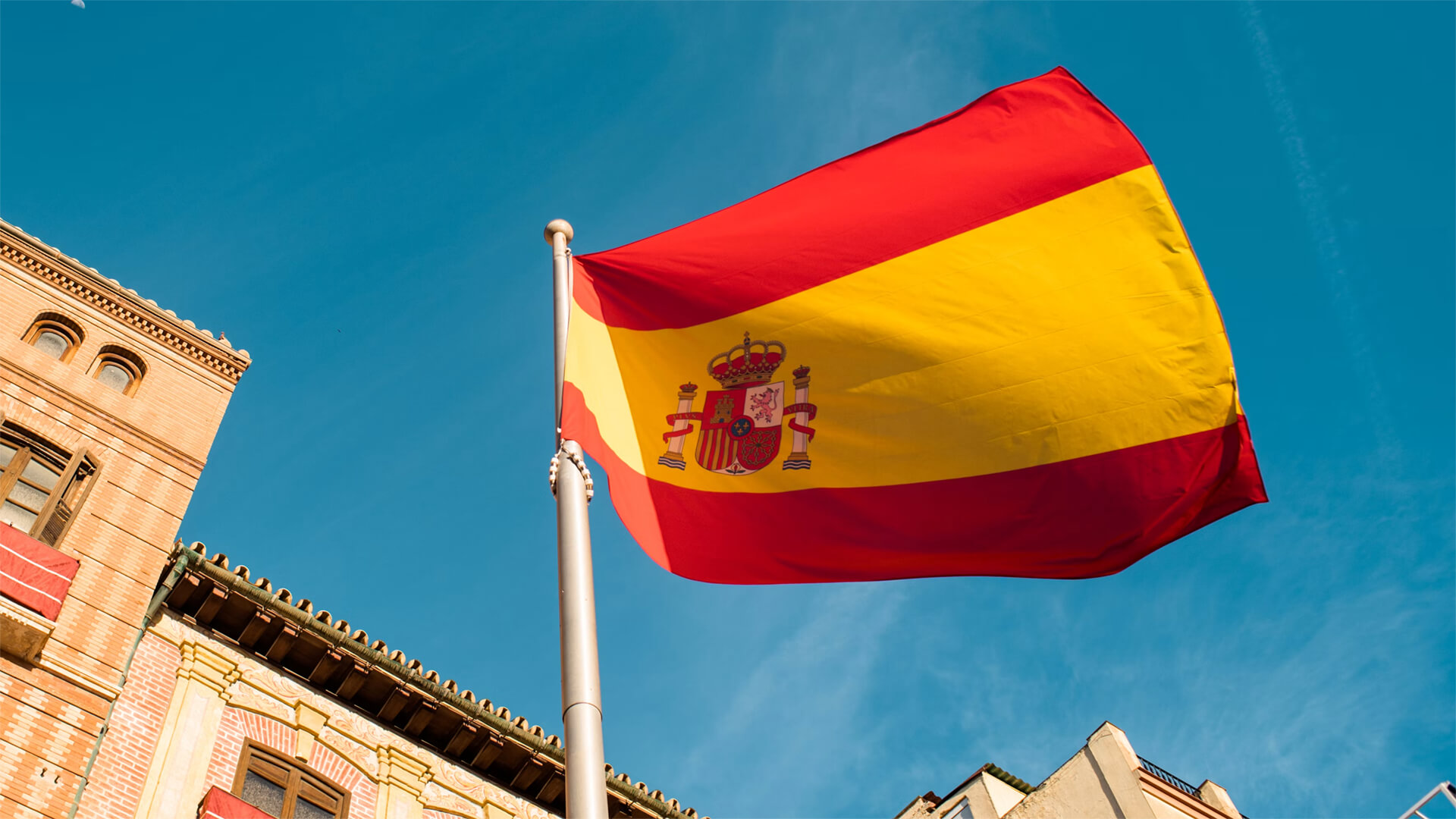 Flag of Spain waving in the wind in front of a building