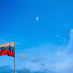 Russian flag at dusk with a moon in the background