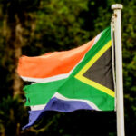 Flag of South Africa behind a jungle landscape