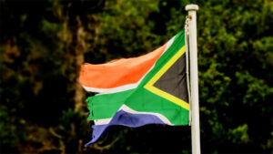 Flag of South Africa behind a jungle landscape
