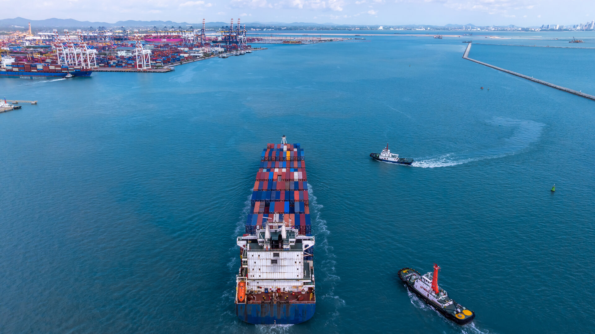 Shipping containers being transported by a cargo hauler in a strait | Licensed by Envato Elements