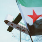 Syrian flag waving with a syrian box airplane in the background