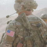 A US military soldier in fatigues with weapon slung on his back