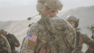 A US military soldier in fatigues with weapon slung on his back